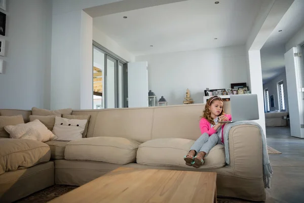 Meisje met laptop in de woonkamer — Stockfoto