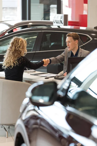 Salesman doing handshake with female customer — Stock Photo, Image