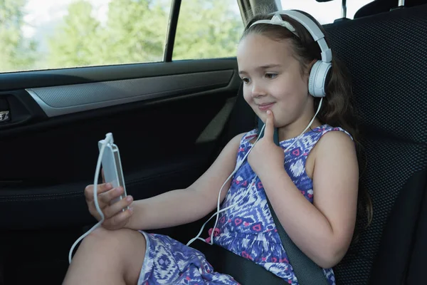 Κορίτσι που χρησιμοποιούν κινητό τηλέφωνο ενώ ακούτε μουσική — Φωτογραφία Αρχείου