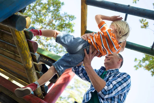 Padre ayudando a su hijo a jugar en el gimnasio de la selva — Foto de Stock