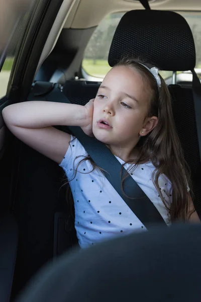 Menina sentada no banco de trás do carro — Fotografia de Stock