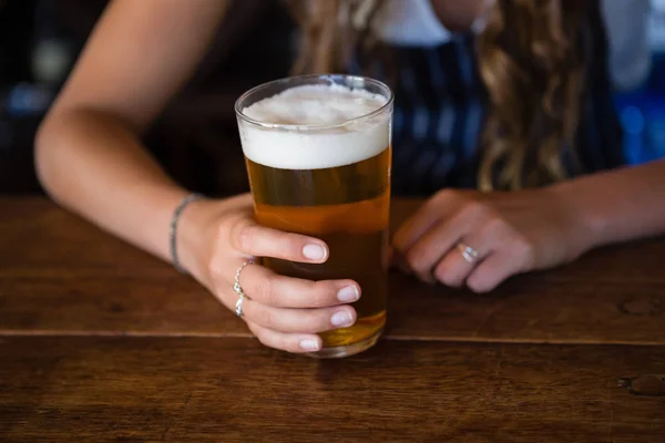 Midsection of barmaid with beer glass — Stock Photo, Image