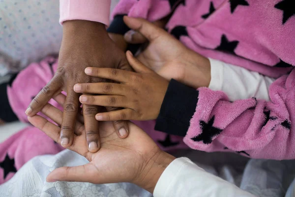 Οικογένεια σχηματίζοντας στοίβα χέρι παίζοντας στο κρεβάτι — Φωτογραφία Αρχείου