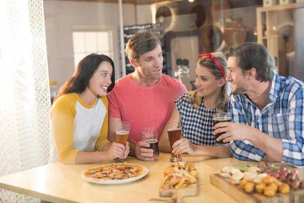 Amis parler tout en ayant de la bière au restaurant — Photo