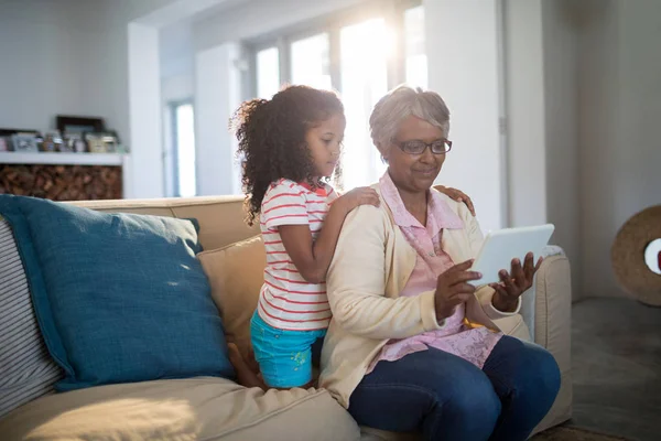 Бабуся і онука використовують планшет на дивані — стокове фото