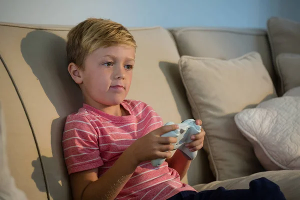 Jongen afspelen van video game in de woonkamer — Stockfoto