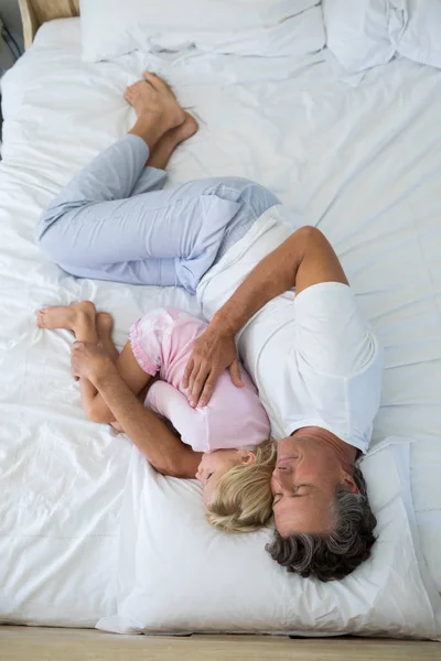 Vader en dochter samen slapen op bed — Stockfoto