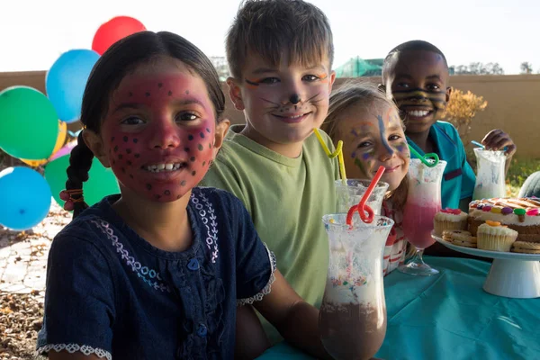 Děti s barvou tváře sedí potraviny a nápoje — Stock fotografie