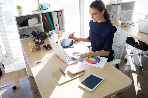 Executivo feminino trabalhando sobre tablet gráfico — Fotografia de Stock