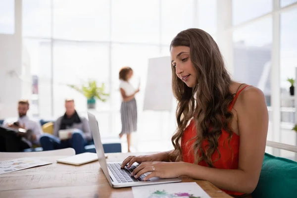 Female executive working on laptop at desk — Stock Photo, Image