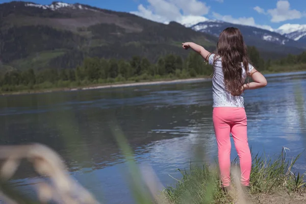 Rear view of girl pointing at mountain — Stock Photo, Image