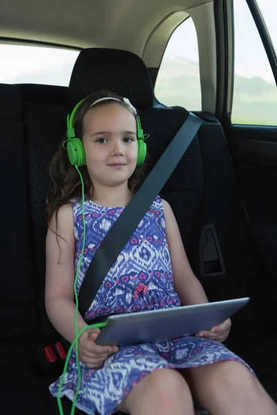 Menina ouvir música no fone de ouvido a partir de tablet digital — Fotografia de Stock