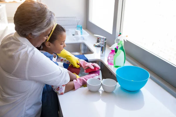 Abuela y nieta lavando utensilios — Foto de Stock