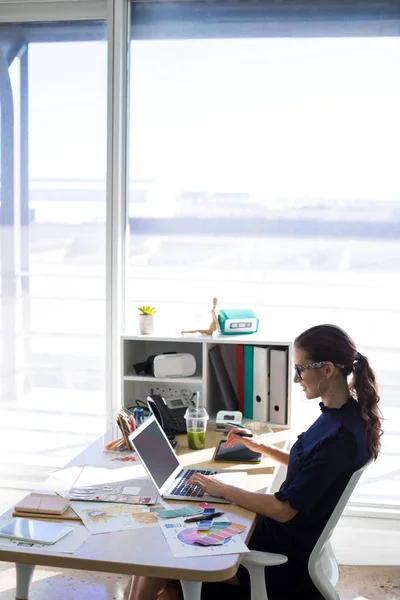 Executivo feminino trabalhando sobre laptop e tablet — Fotografia de Stock