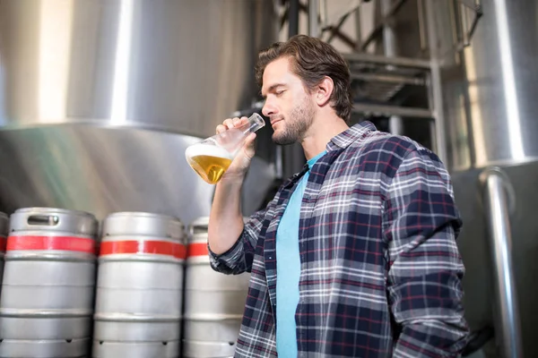 Homem examinando cerveja — Fotografia de Stock