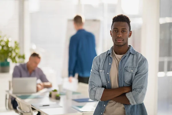 Männliche Führungskraft steht mit verschränkten Armen im Büro — Stockfoto