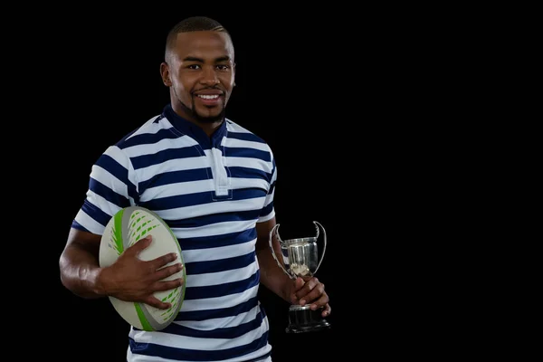 Athlète masculin avec ballon de rugby et trophée — Photo