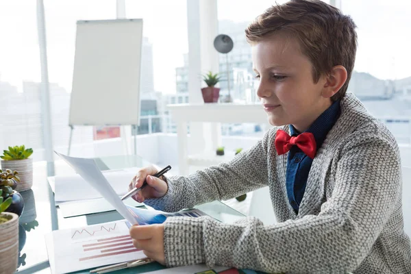 Pojke som företagsledare att verifiera dokument — Stockfoto