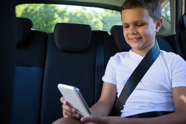 Adolescente niño usando el teléfono en el coche — Foto de Stock