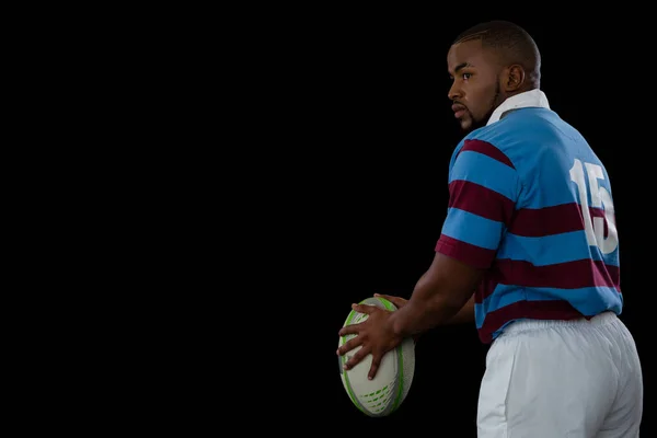 Deportista sosteniendo pelota de rugby mientras mira hacia otro lado —  Fotos de Stock