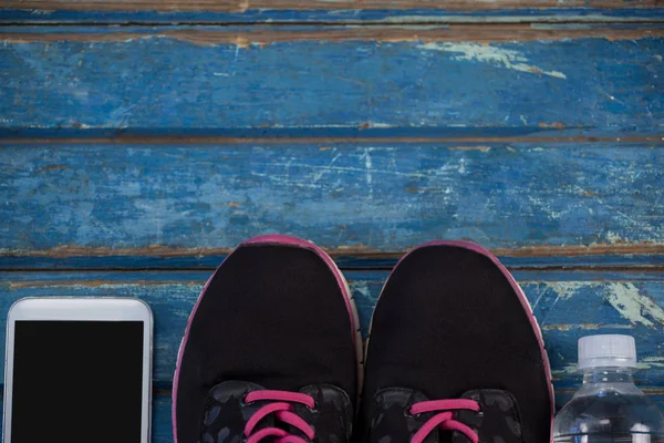 Zapatos deportivos en medio del teléfono móvil —  Fotos de Stock