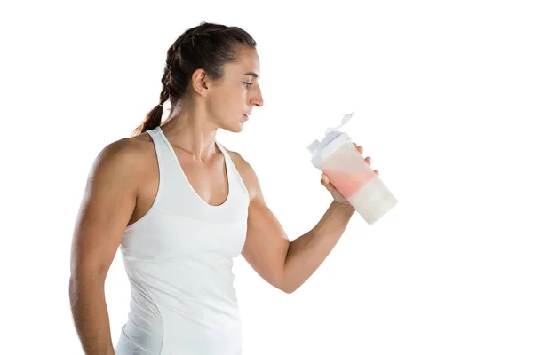 Atleta femenina mirando la botella de bebida —  Fotos de Stock