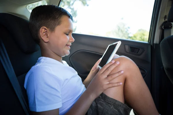 Menino adolescente usando tablet no carro — Fotografia de Stock