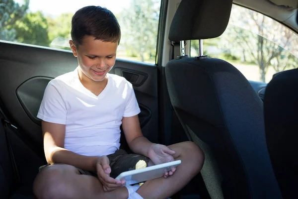 Menino adolescente usando tablet no carro — Fotografia de Stock