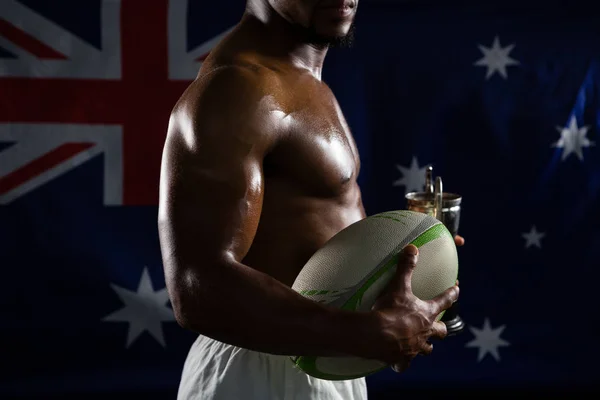 Homem sem camisa com troféu e bola de rugby — Fotografia de Stock