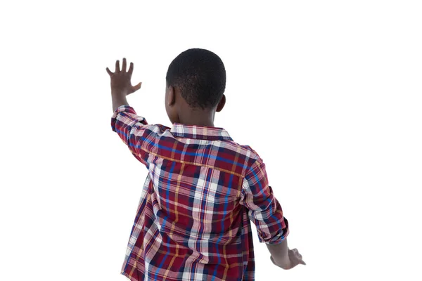 Junge gibt vor, einen unsichtbaren Bildschirm zu berühren — Stockfoto