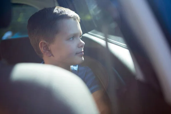 Arabanın arka koltuğunda oturan genç çocuk — Stok fotoğraf