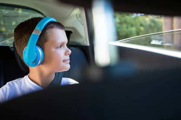 Arabada kulaklıklarla genç çocuk — Stok fotoğraf