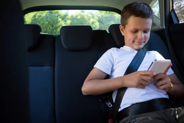 Adolescente menino usando telefone no carro — Fotografia de Stock