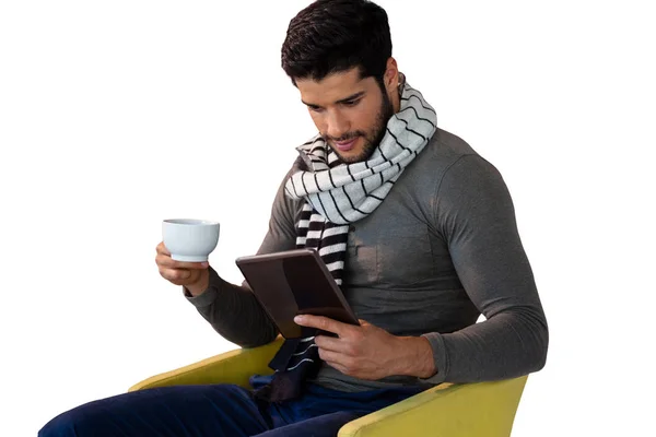 Hombre usando tableta mientras toma una taza de té — Foto de Stock