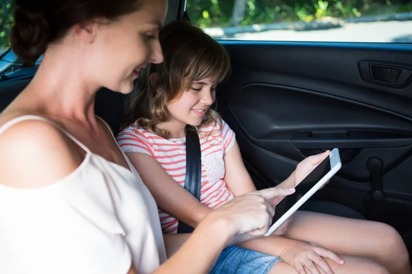 Moeder en dochter met behulp van Tablet PC in de auto — Stockfoto