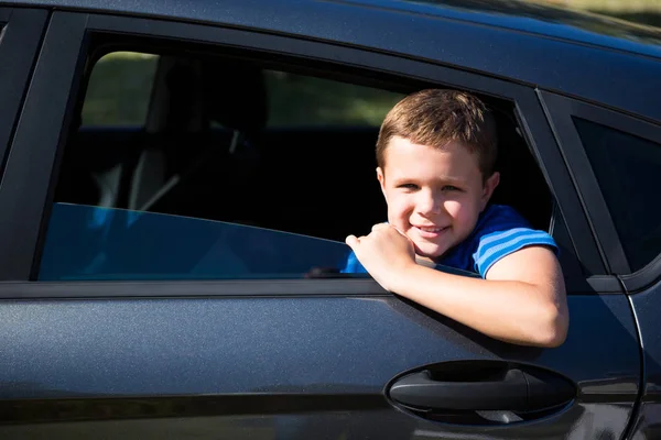 Tonårspojke söker från öppen bilfönster — Stockfoto