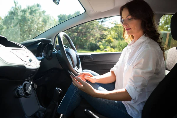 Mujer usando el teléfono mientras conduce el coche —  Fotos de Stock