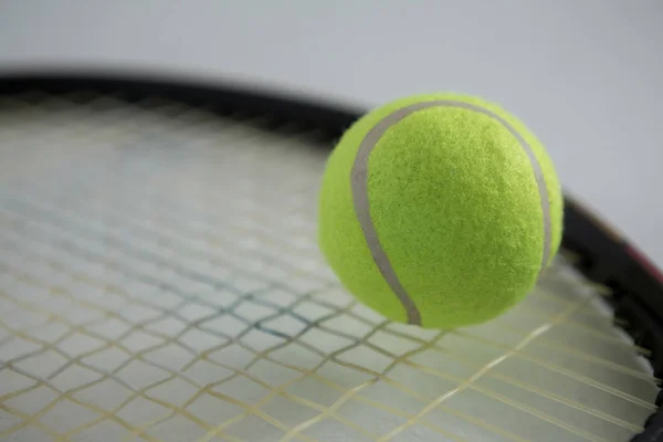 Флуоресцентный теннисный мяч на ракетке — стоковое фото
