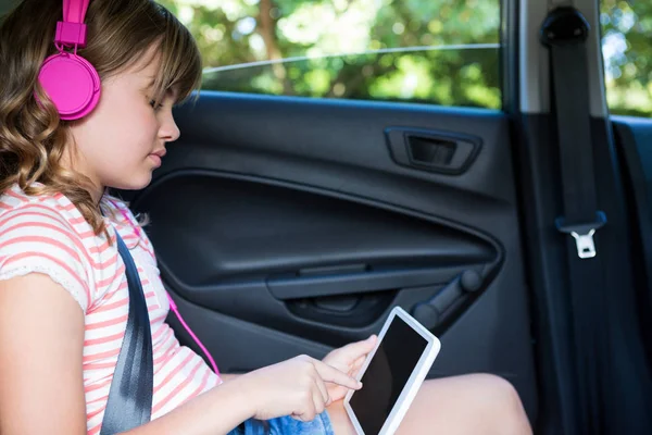 Adolescente en auriculares usando tableta — Foto de Stock