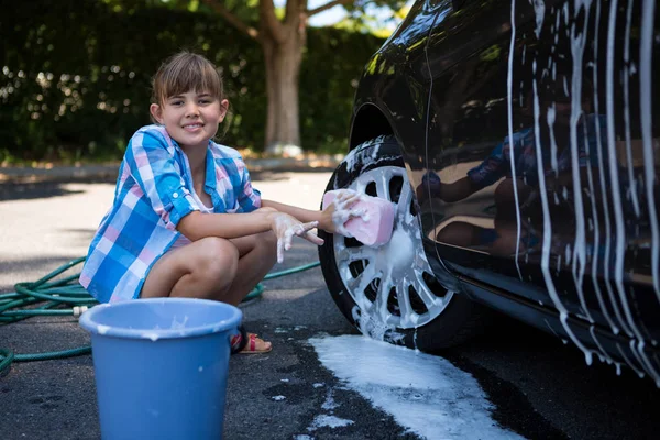 Teenager-Mädchen wäscht Auto an sonnigem Tag — Stockfoto