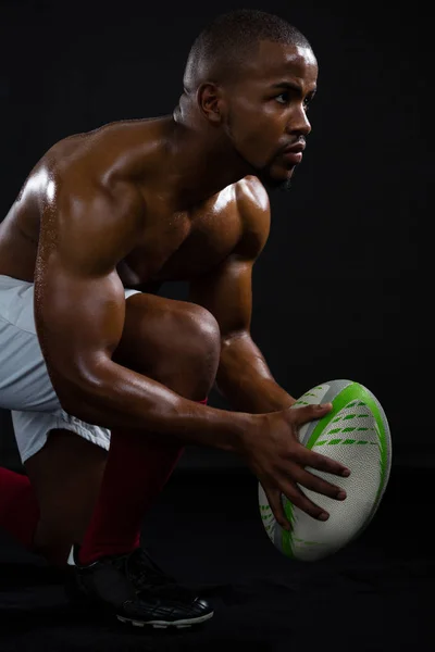 Sem camisa desportista segurando bola de rugby — Fotografia de Stock