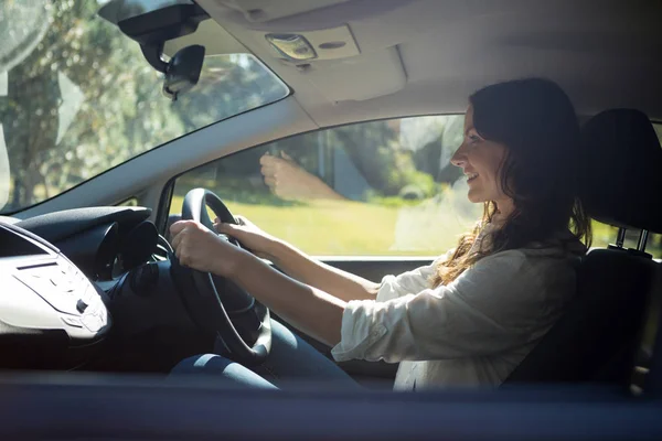 Lachende vrouw besturen van een auto — Stockfoto