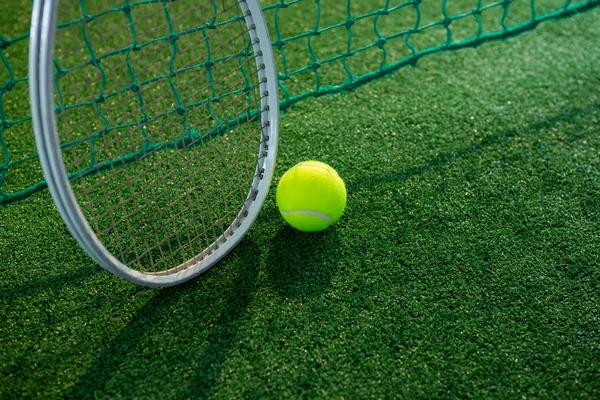 Pelota de tenis con raqueta por red —  Fotos de Stock