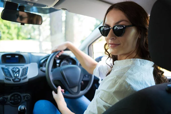 Mujer sonriente conduciendo un coche — Foto de Stock