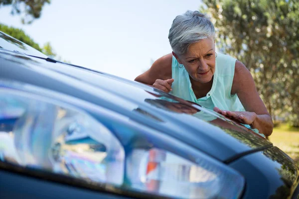 Mujer mayor revisando su coche —  Fotos de Stock