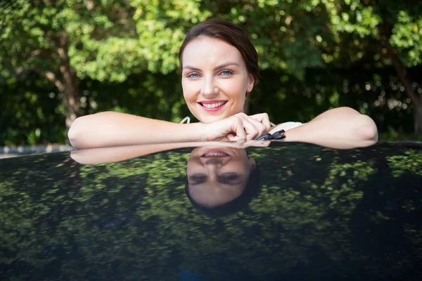 Mooie vrouw leunend op een auto — Stockfoto