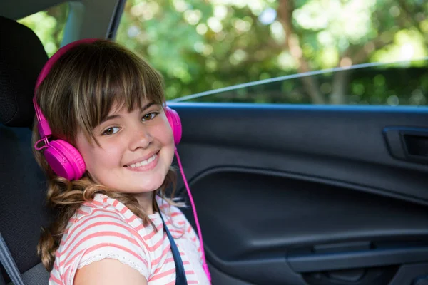 Adolescente com fones de ouvido no carro — Fotografia de Stock