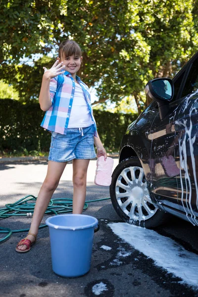 Adolescente chica lavando un coche — Foto de Stock