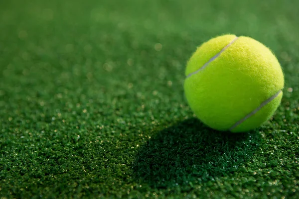 Fluorescerande gul tennisboll på gräs — Stockfoto