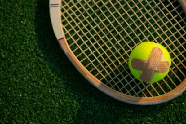 Tennis ball with bandage on racket — Stock Photo, Image